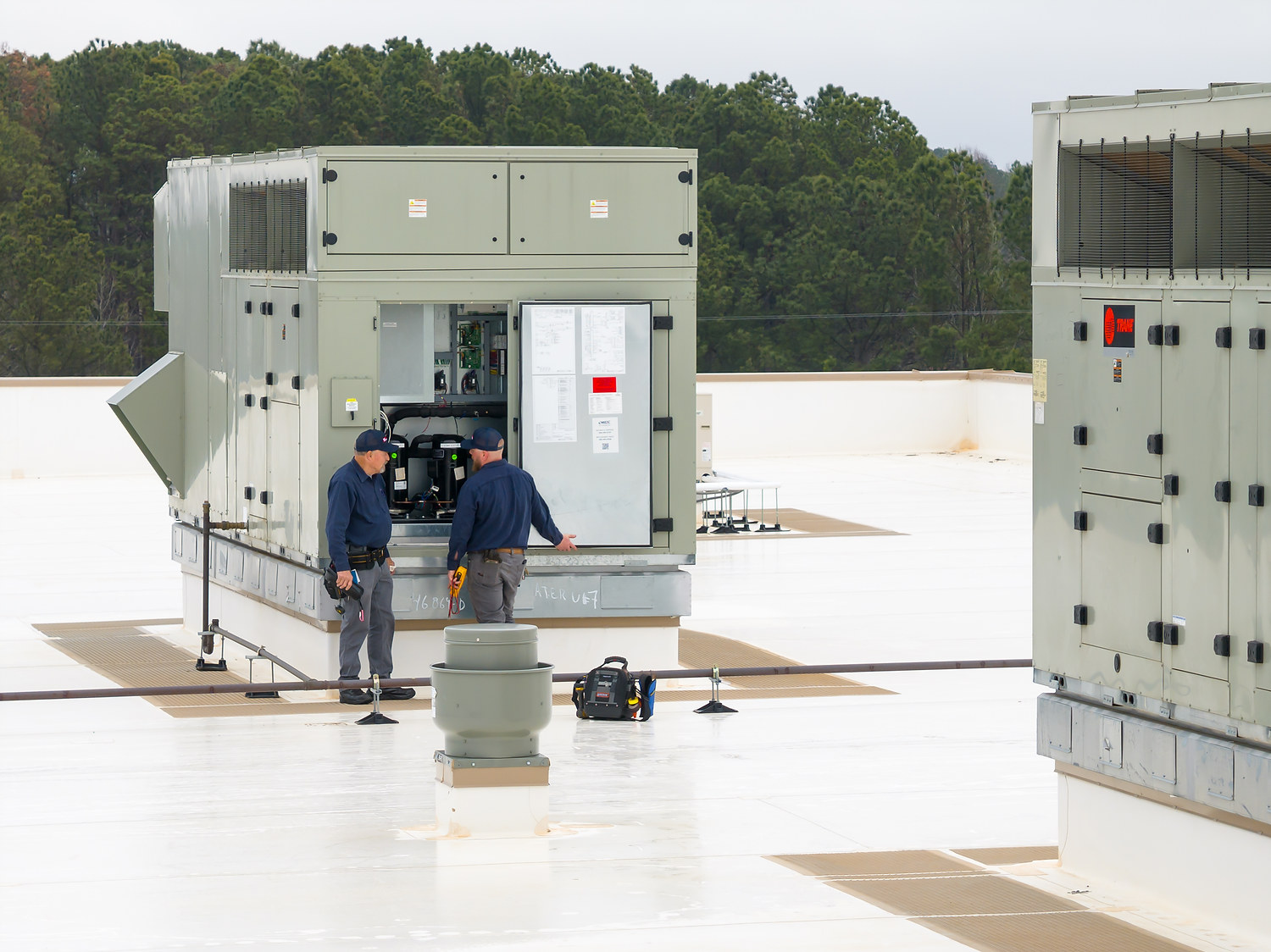 Technicians Inspecting Rooftop HVAC Unit