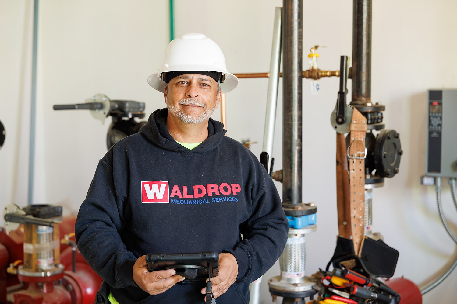 HVAC technician with diagnostic tool in mechanical room